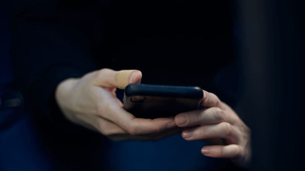 person's hands holding a black phone
