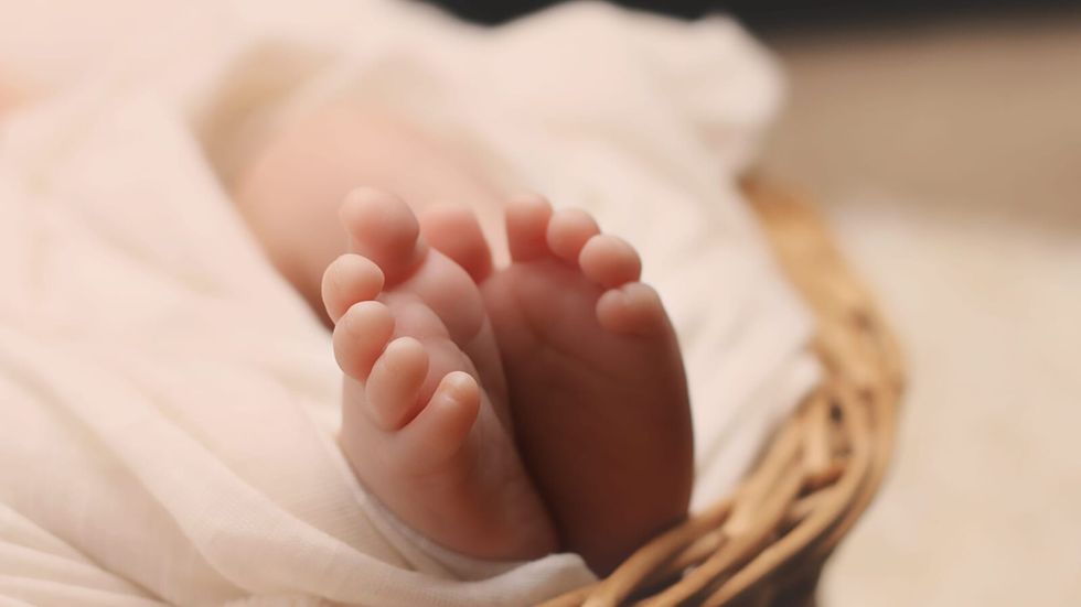 baby's feet in a brown wicker basket
