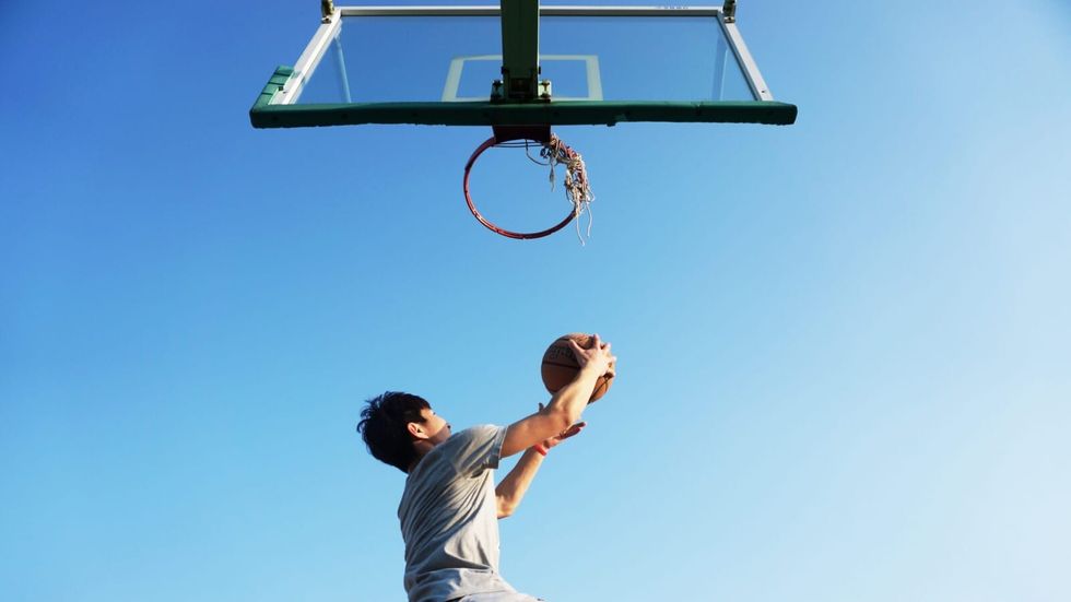 man dunking a ball into a basket