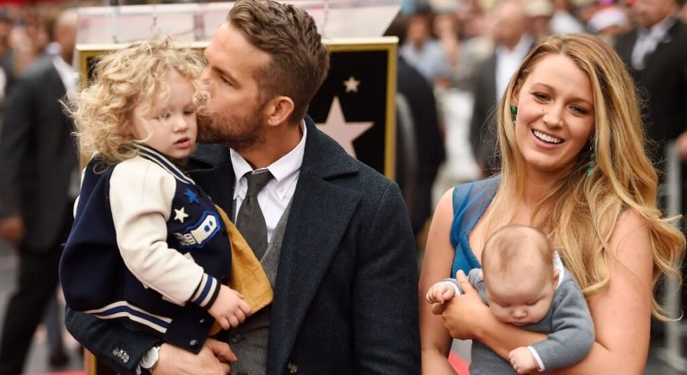 Blake Lively and Ryan Reynolds holding their two children.