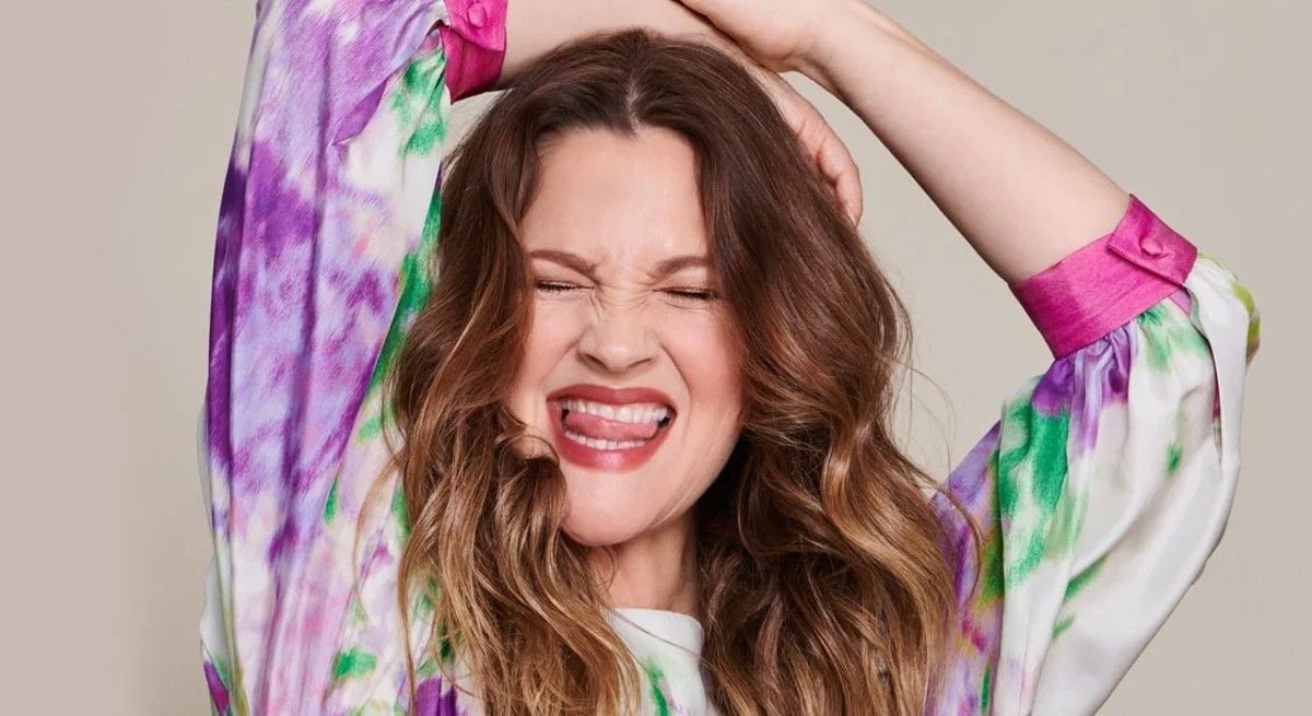 Drew Barrymore laughing and sticking her tongue out at the camera.
