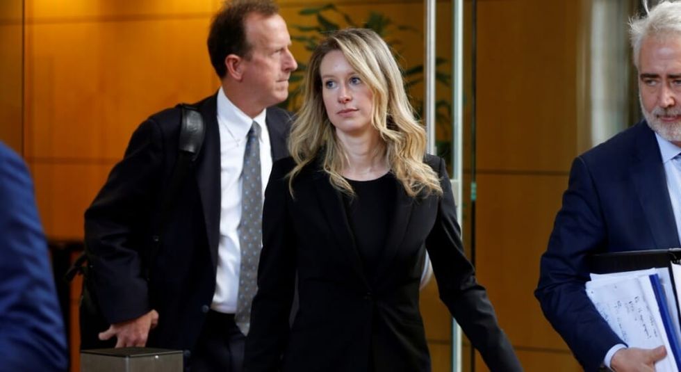Elizabeth Holmes in black suit leaving the courthouse.