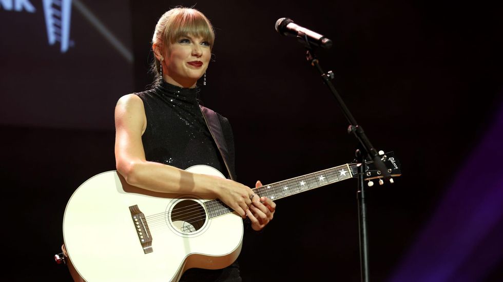taylor swift on stage holding a guitar