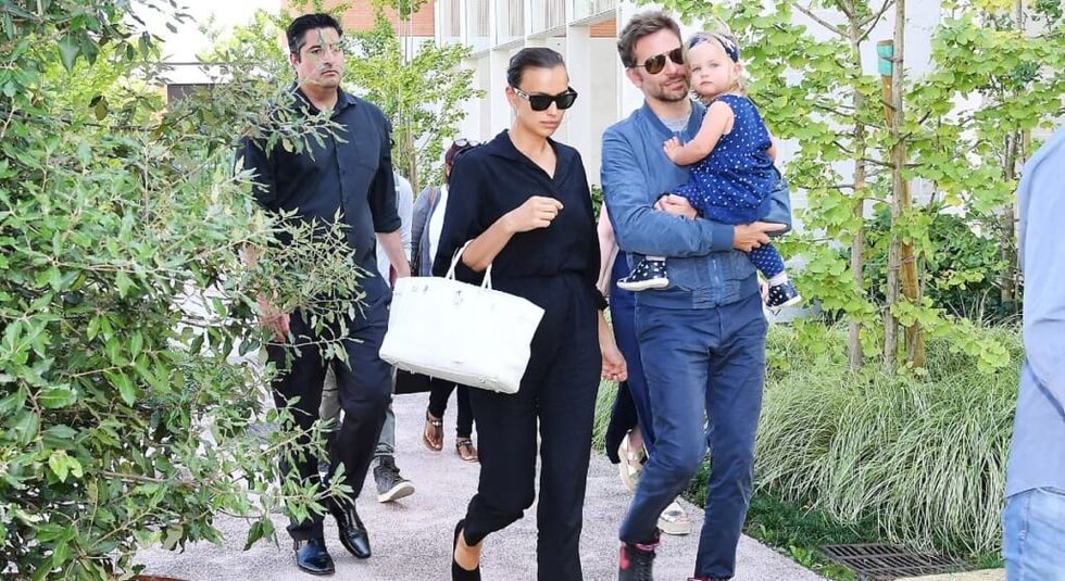 Bradley Cooper and Irina Shayk walk down the street with their daughter.