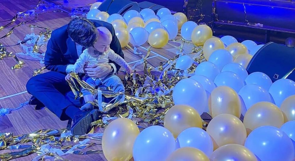 John Mulaney on his 40th birthday holding son Malcolm surrounded by balloons.