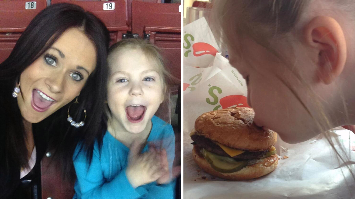 woman taking a photo with a little girl and a girl kissing a burger