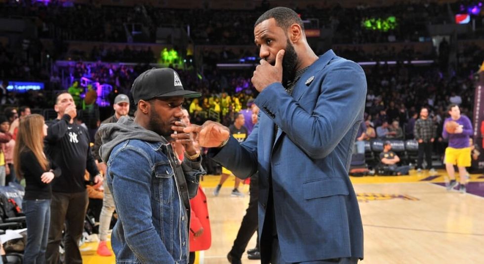 Rich Paul talking to Lebron James on at a babsketball game.