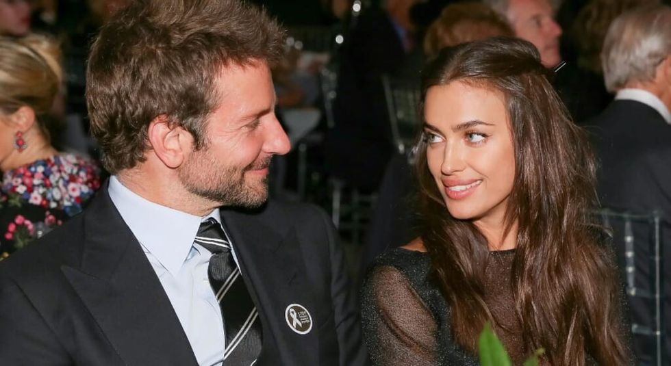 Bradley Cooper in black suit and tie with ex-girlfriend Irina Shayk smiling at each other.