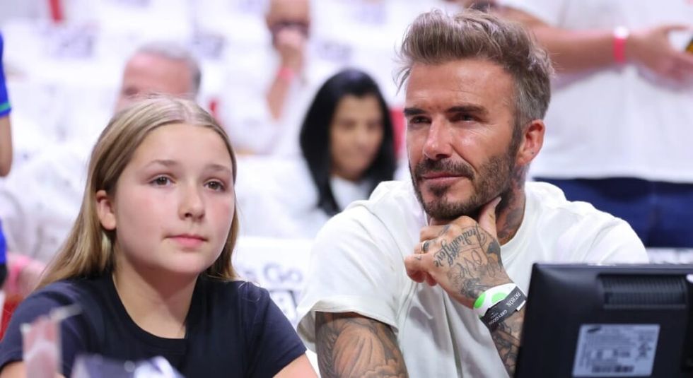 David Beckham with daughter Harper at tennis match.
