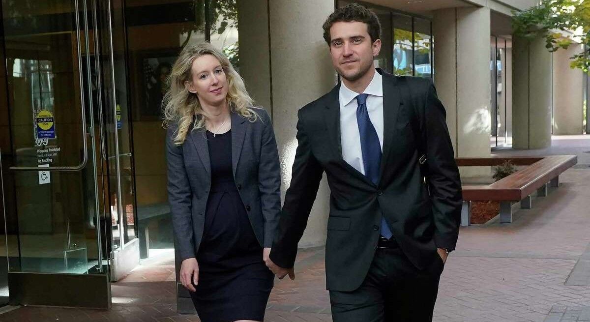 Elizabeth Holmes and husband Billy Evans holding hands outside the courtroom.
