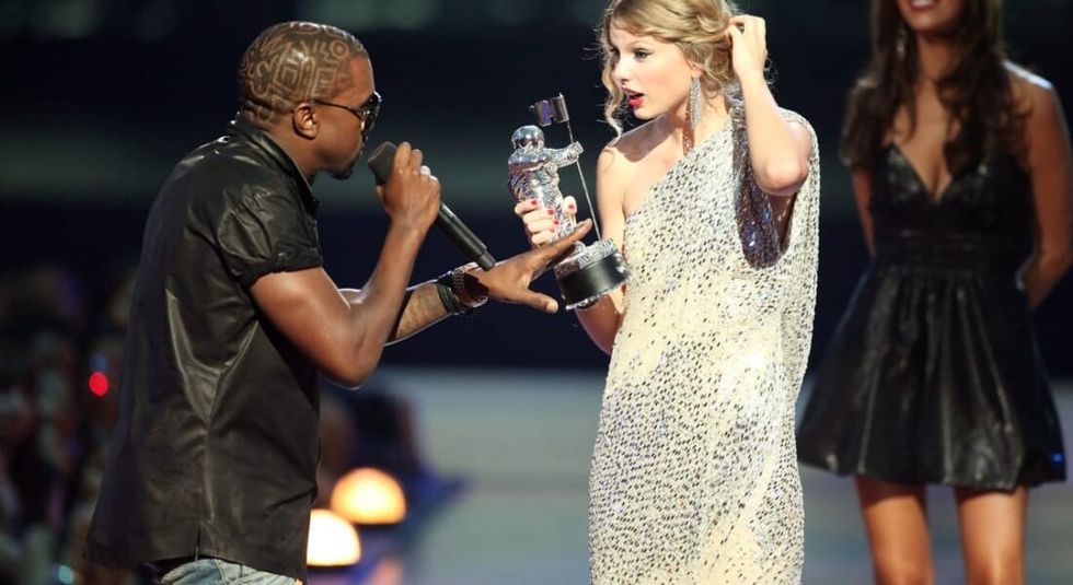 Kanye West grabbing Taylor Swift's microphone after she won an award.