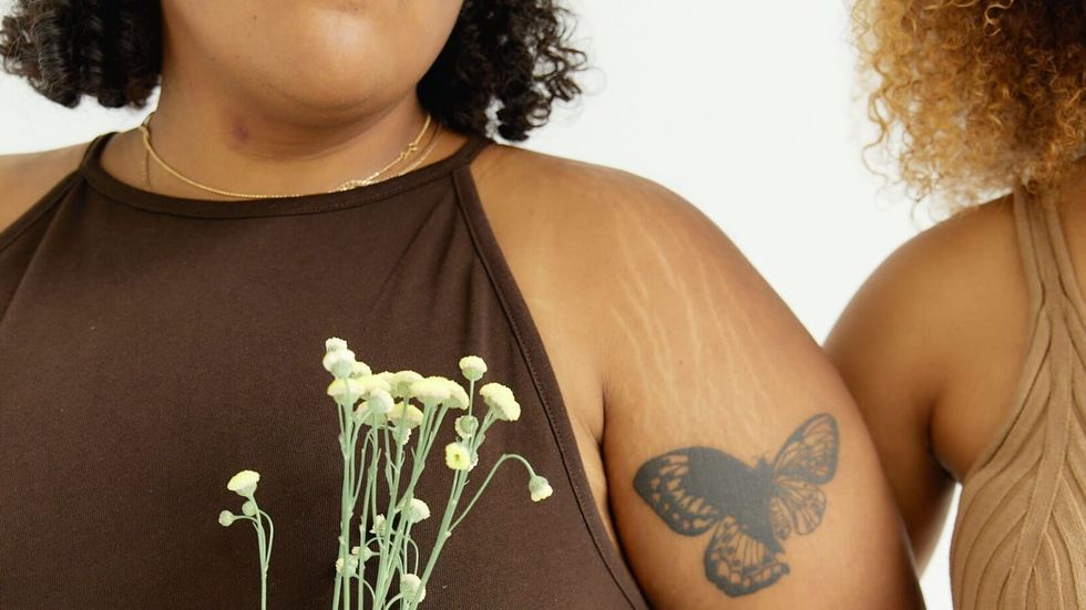 woman with butterfly tattoo holding flowers