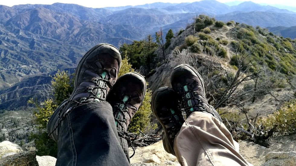 two pairs of shoes against a mountain backdrop