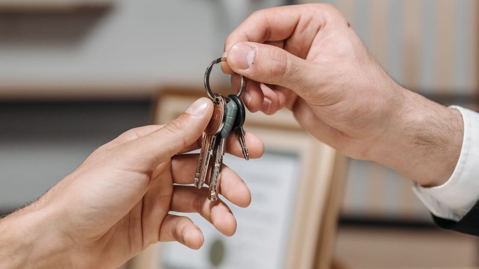 one person giving keys to another person