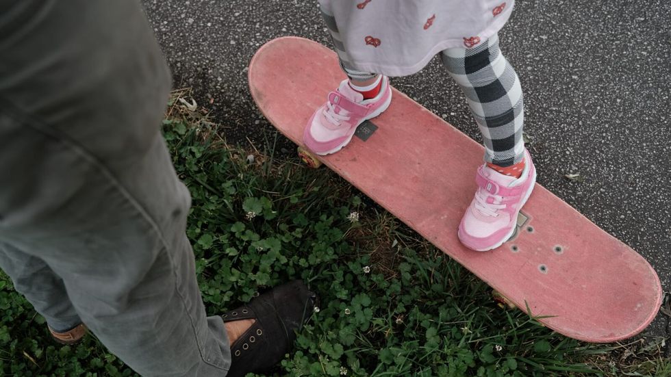 child on a pink skateboard