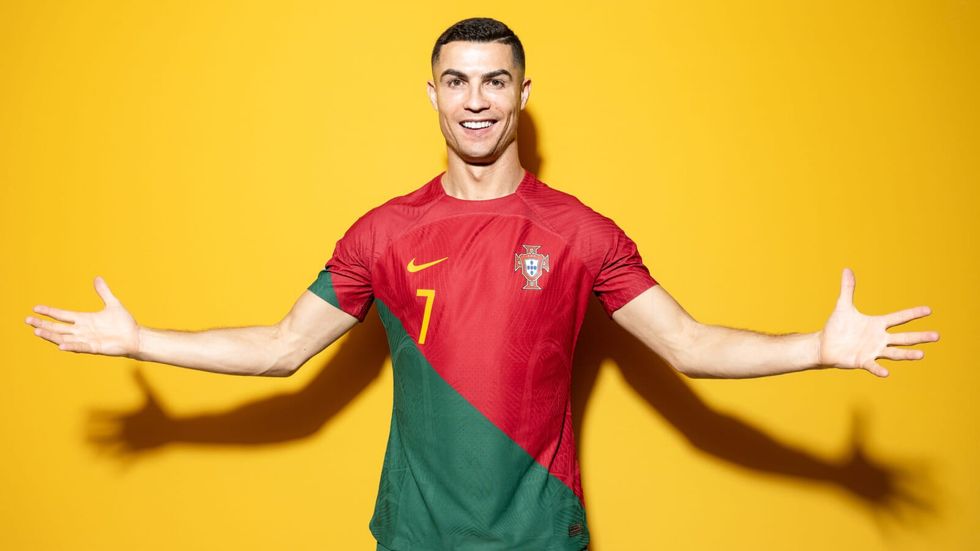 man wearing a red and green jersey standing in front of a yellow background