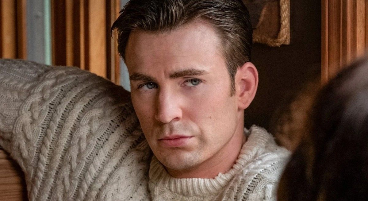 Chris Evans wearing a white sweater staring at the camera.