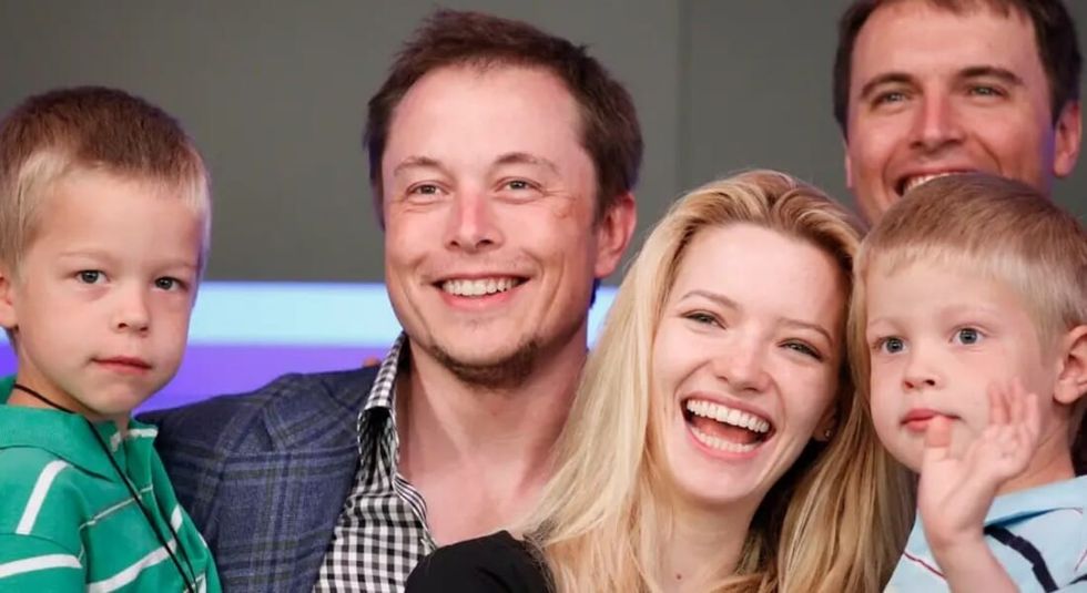 Elon Musk posing with two of his children.