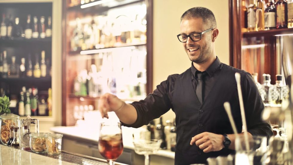 man making drinks at a bar
