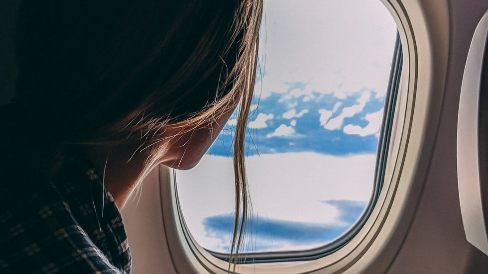 woman looking out of an airplane window