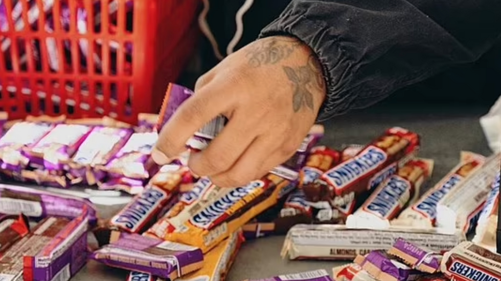 a person's hand holding snicker bars