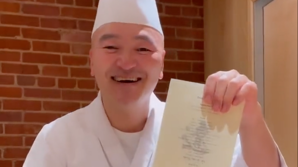 chef holding a menu in his hand