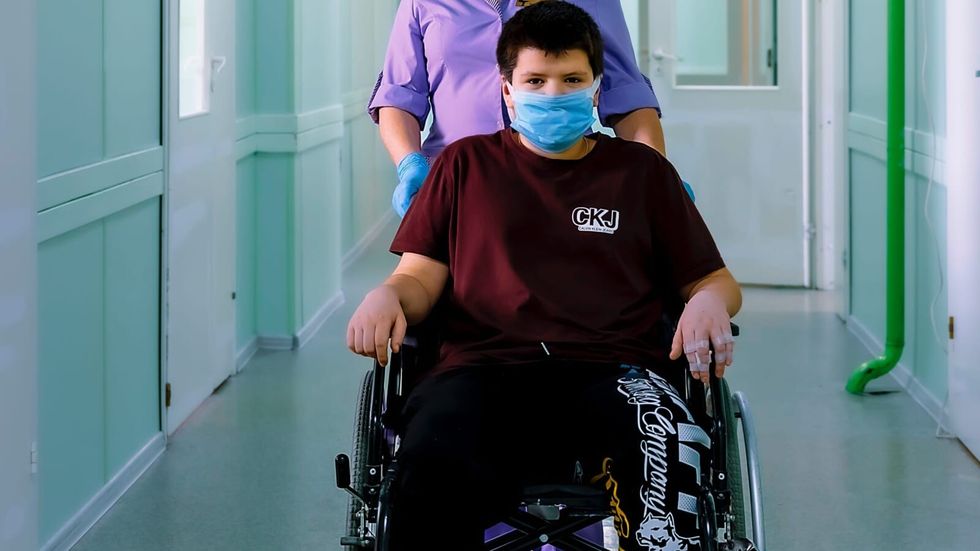 nurse pushing boy in a wheelchair