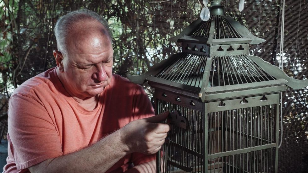 man with a bird cage