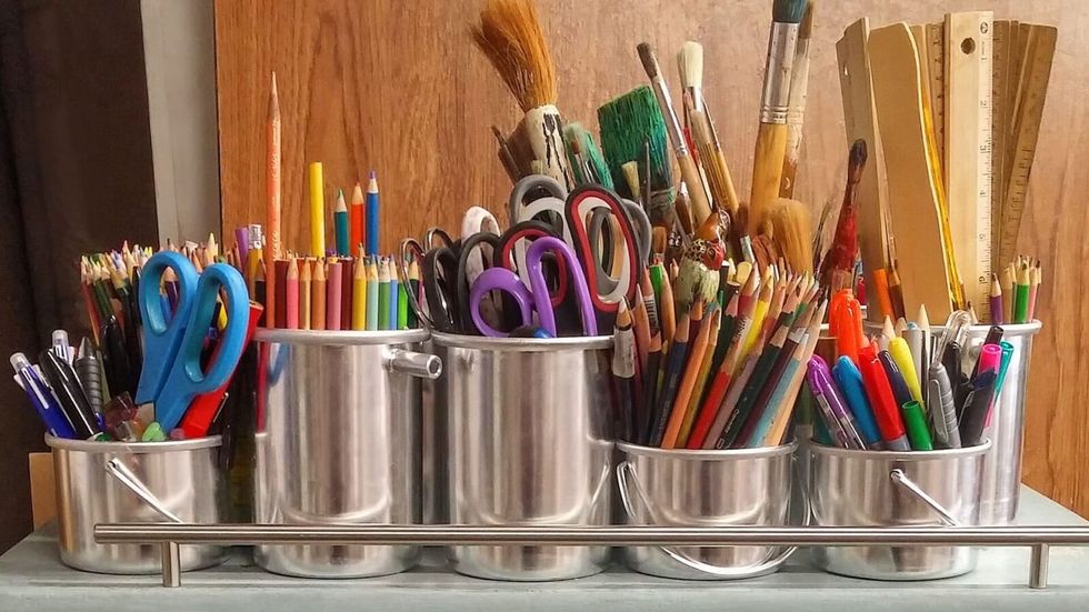 pens, pencils, paint brushes in steel containers