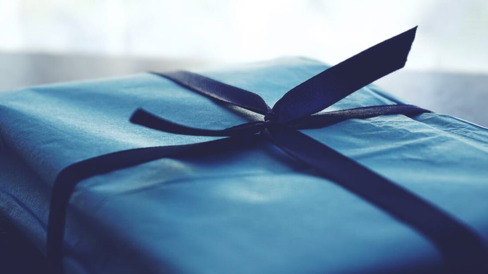 close up of a blue gift tied with ribbon