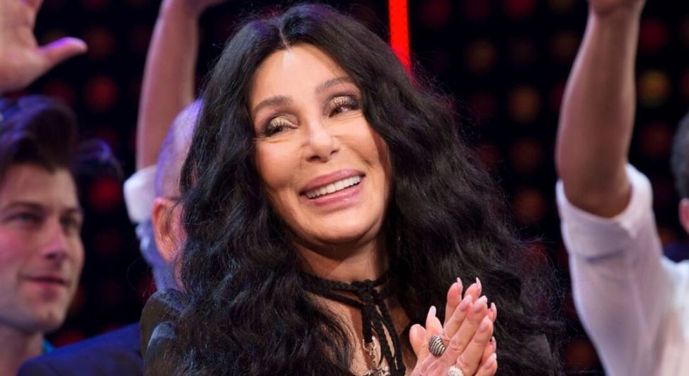 Cher clapping her hands in the audience.