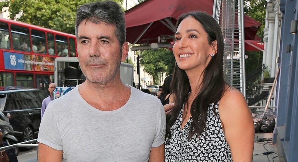 Simon Cowell and wife Laura Silverman walking down the road.