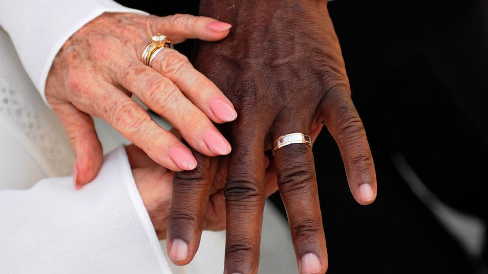 two people wearing rings and holding hands