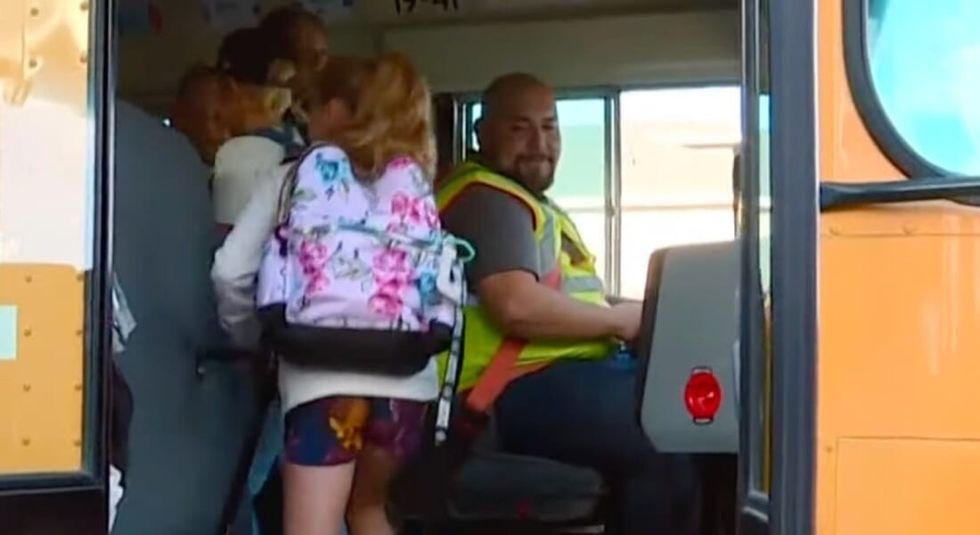 Kids boarding a yellow school bus. 