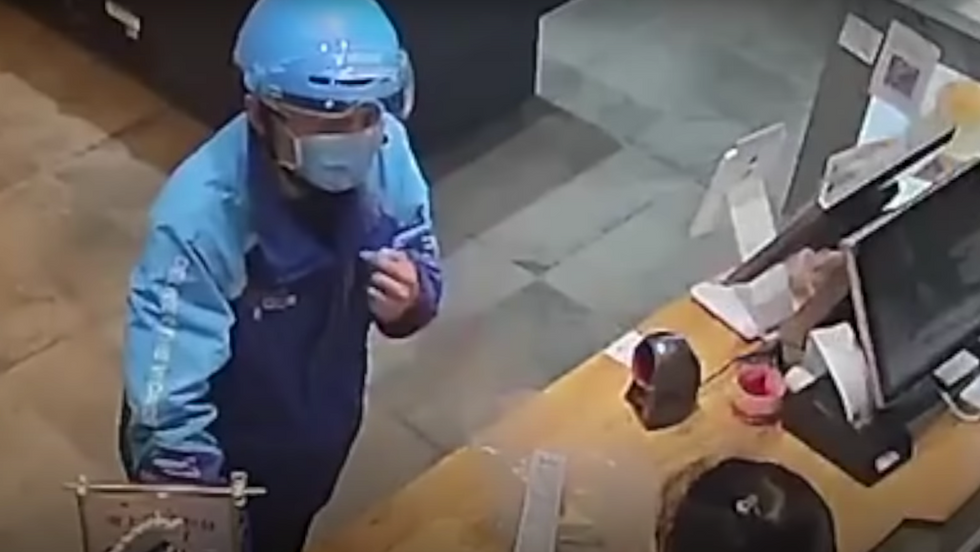 A delivery man in blue clothes and a mask