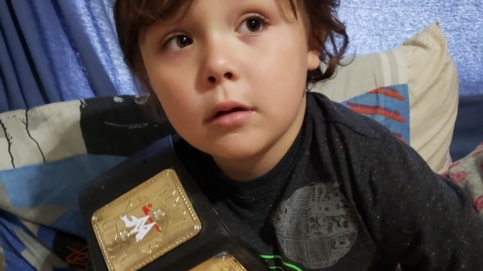 little boy holding a wrestling belt