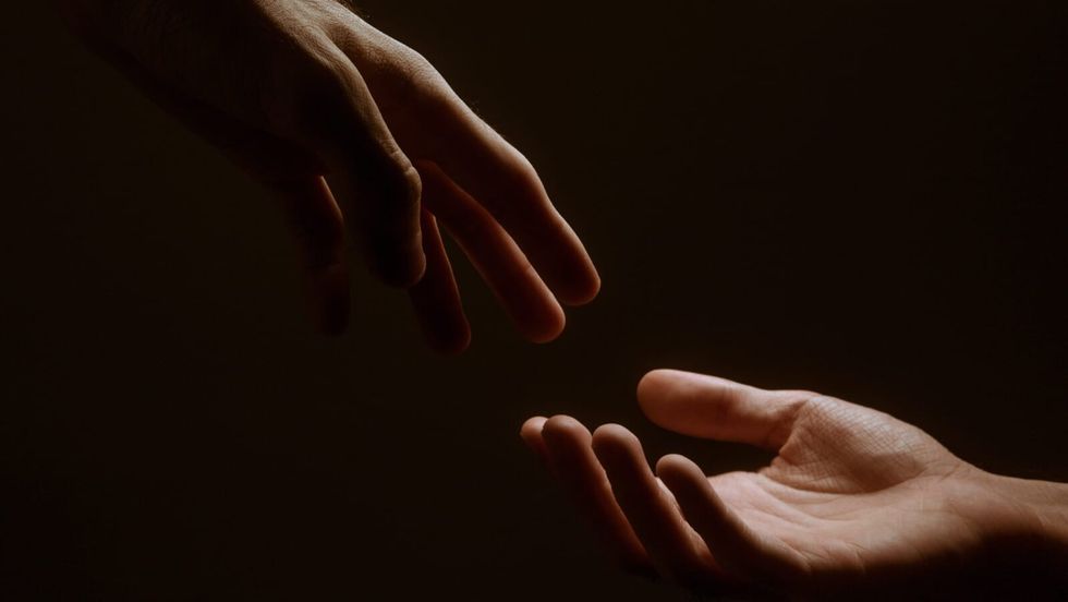 two people's hands reaching out to each other