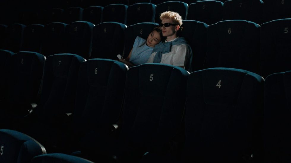 woman laying her head on man's shoulder in an empty movie theatre