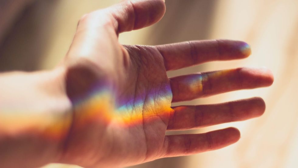 rainbow light on a person's palm