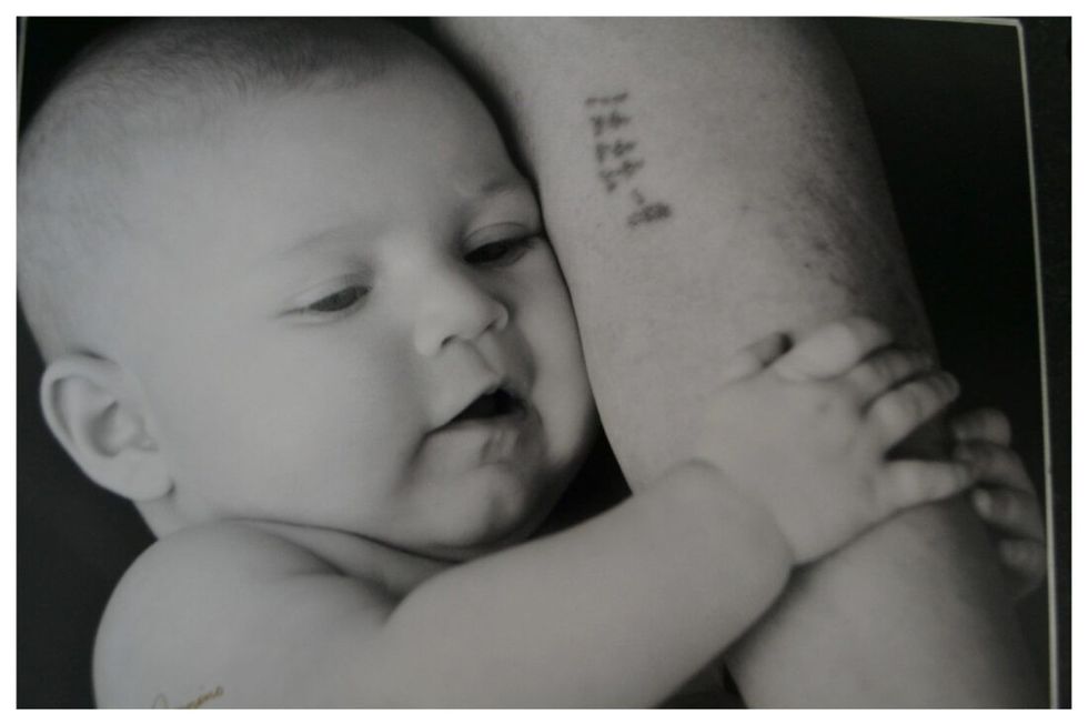 baby holding a person's arm