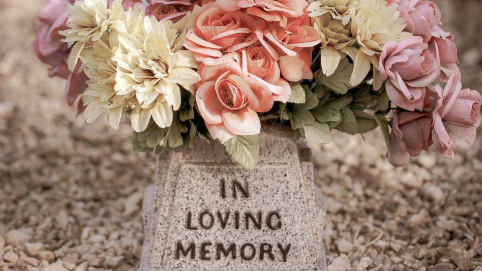 flowers placed on a stone with the inscription "in loving memory"