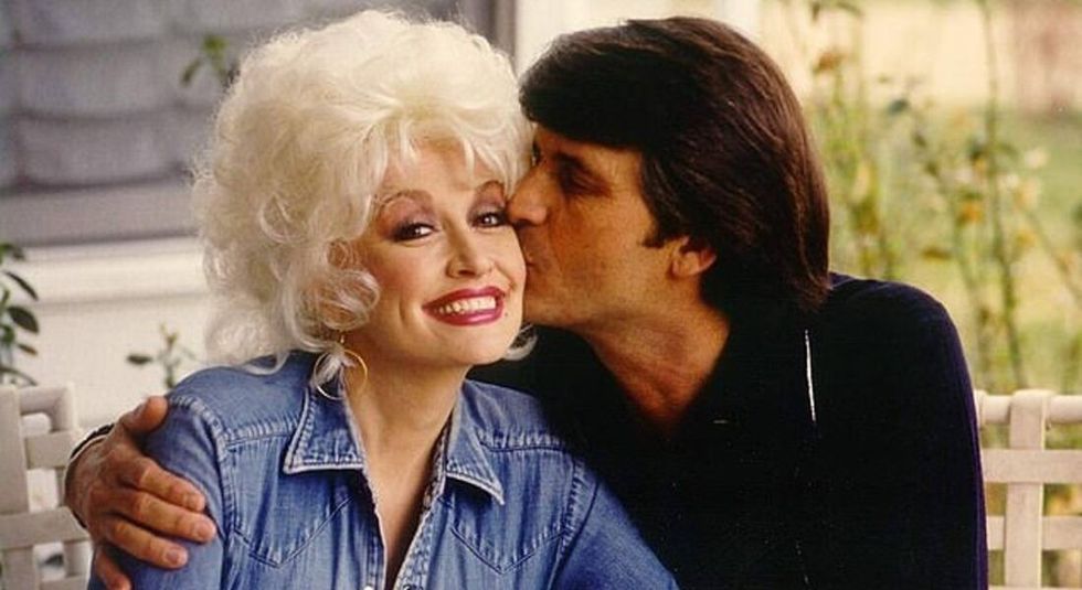 Dolly Parton and husband Carl Dean kissing her on the cheek.