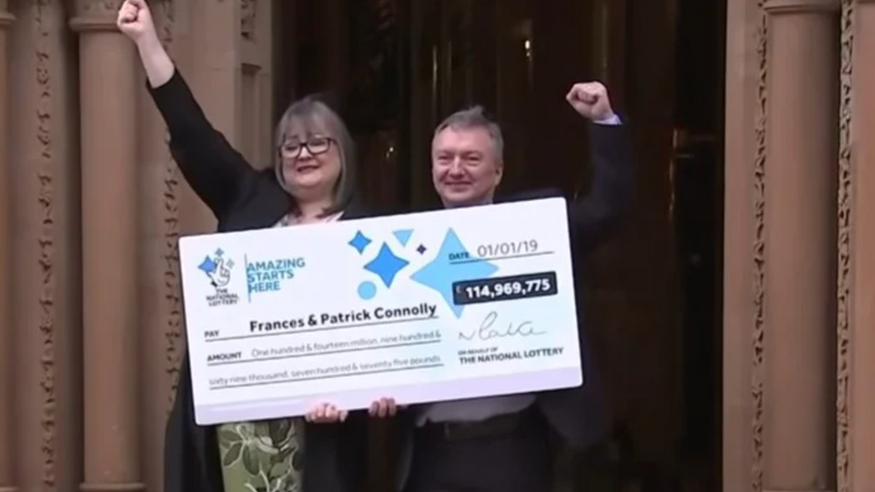 woman and a man holding a big cheque