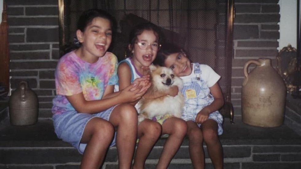 three girls sitting with a dog