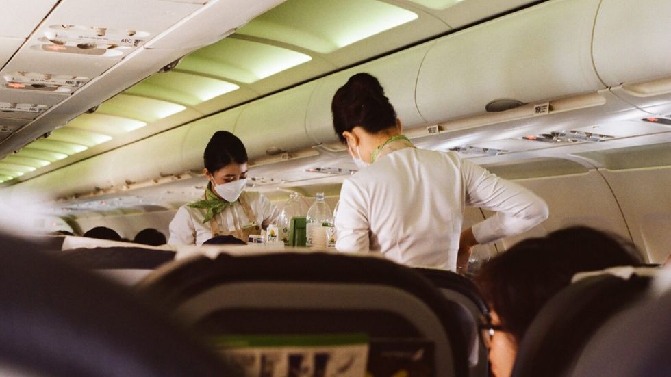 flight attendants pouring drinks for passengers