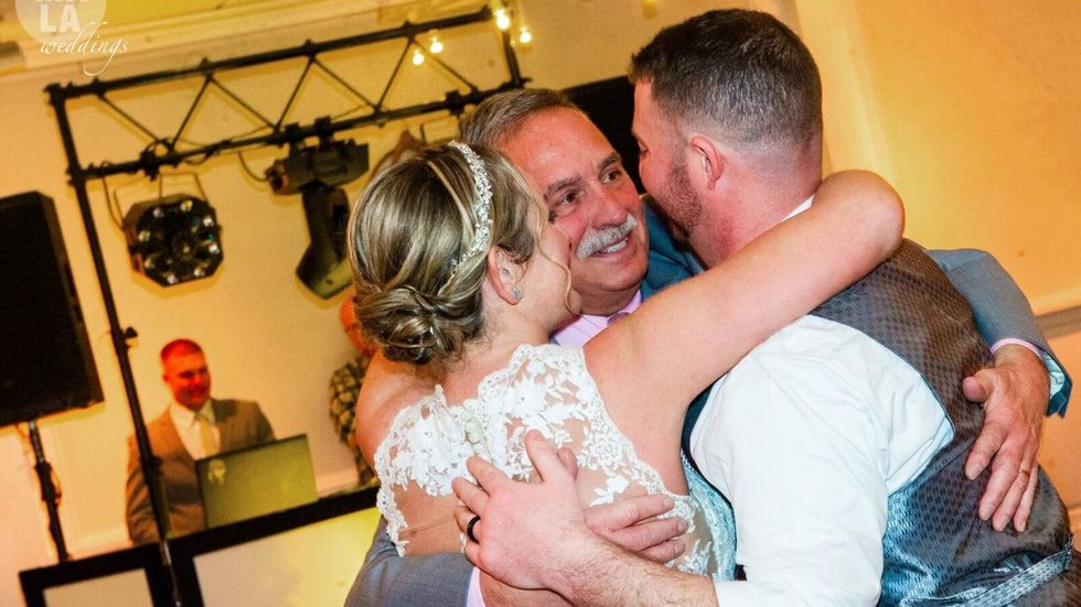 a man hugging a bride and groom