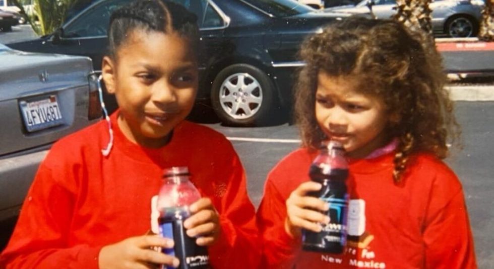 Young Zendaya and her sister wearing matching red sweaters.