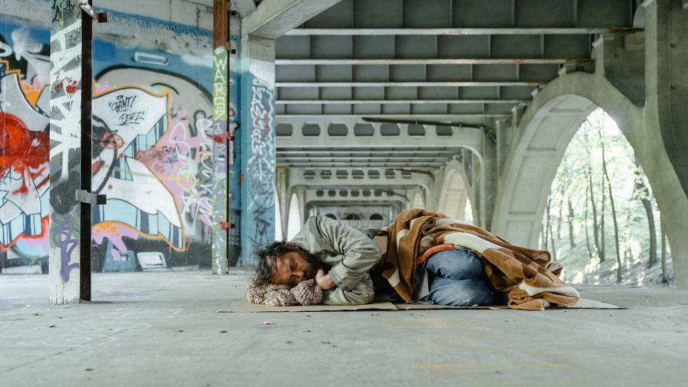homeless man sleeping on the ground