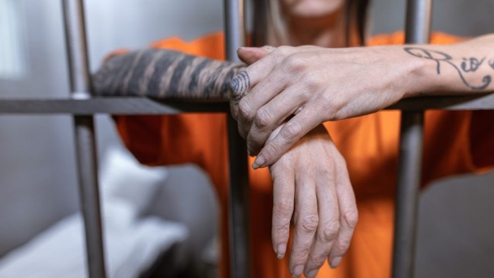 tattooed hands of a person in prison