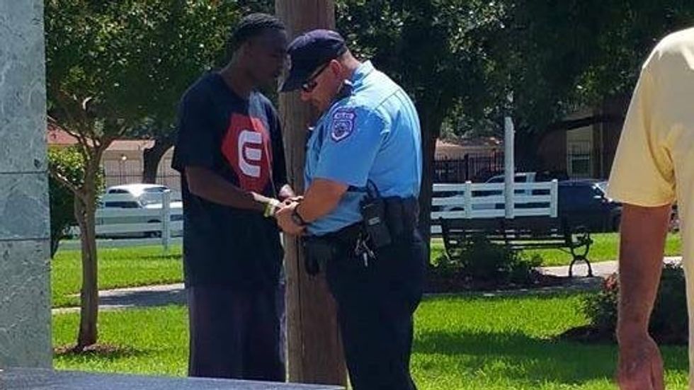 man and police officer holding hands and praying
